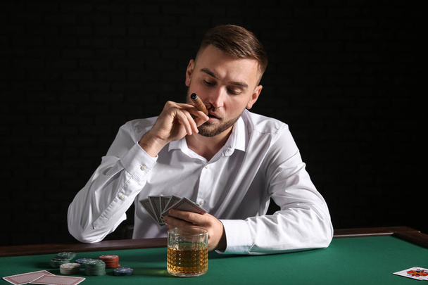 Junger Mann pokert im Casino - Foto, Bild