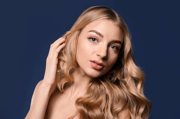 Young woman with beautiful curly hair on color background - Valokuva, kuva