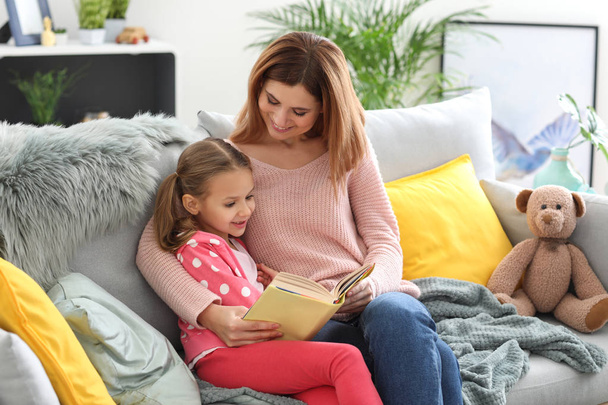 Szczęśliwa matka z córka czytania książki w domu - Zdjęcie, obraz