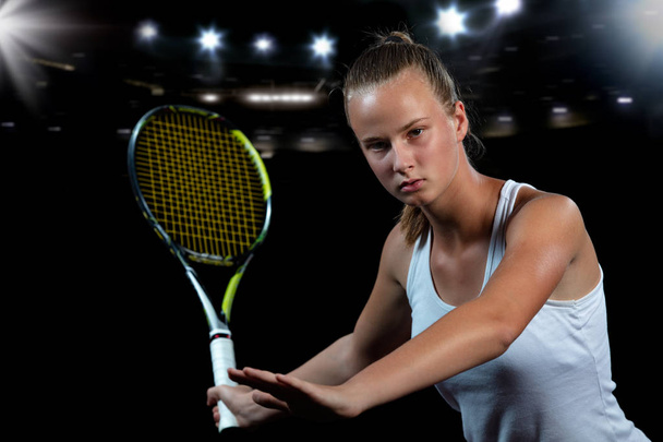 Beautiful girl tennis player with a racket on dark background with lights - Photo, Image
