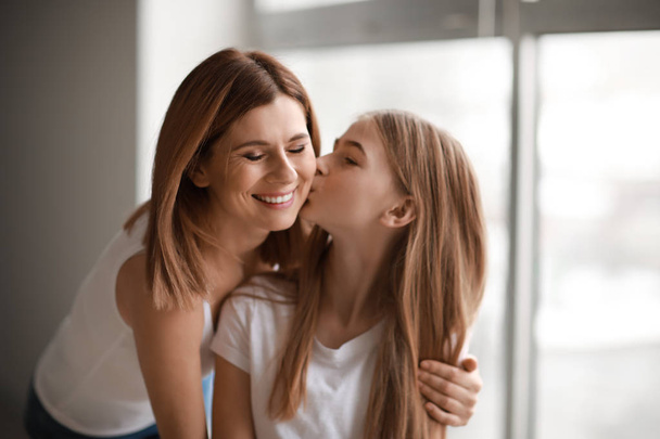 Portrait of happy mother and daughter near window - Photo, image
