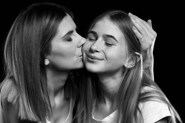 Ασπρόμαυρο πορτρέτο της ευτυχισμένη μητέρα και κόρη σε σκούρο φόντο - Φωτογραφία, εικόνα