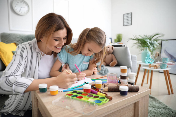 Счастливая мама с дочкой рисуют дома
 - Фото, изображение