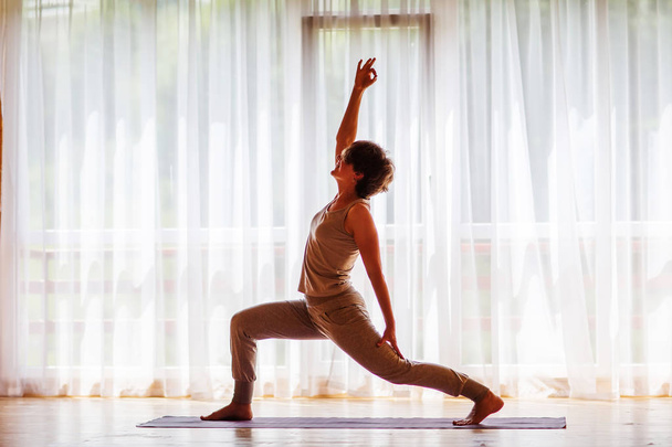 Caucasian woman is practicing yoga at studio - Photo, image