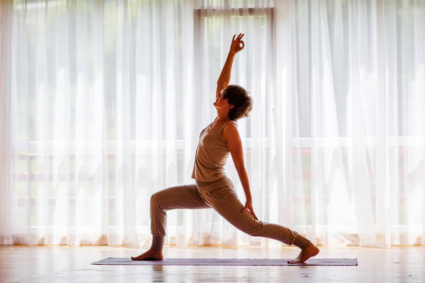 Caucasian woman is practicing yoga at studio - Foto, Imagen