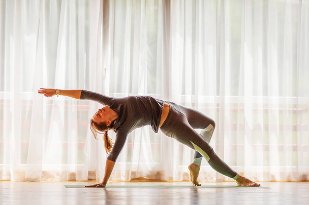 Caucasian woman is practicing yoga at studio - Zdjęcie, obraz