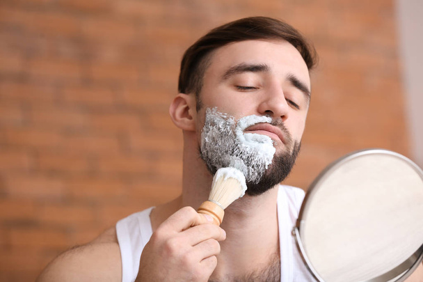 バスルームでひげを剃ってハンサムな男 - 写真・画像