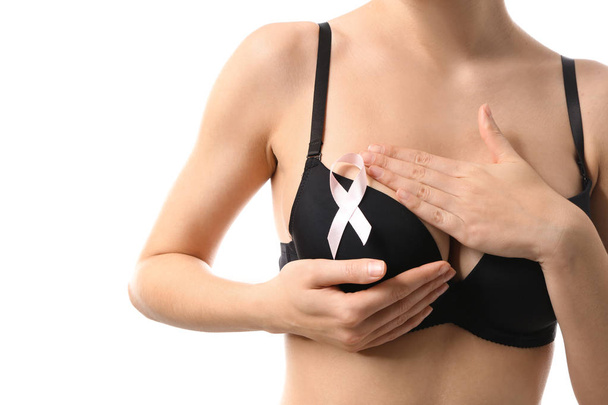 Young woman with beautiful breast and pink ribbon on white background. Cancer awareness concept - Foto, afbeelding
