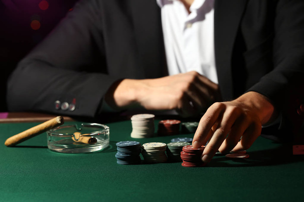 Male player at table in casino - Photo, Image