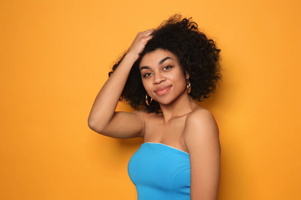 Portrait of young African-American woman on color background - Fotografie, Obrázek