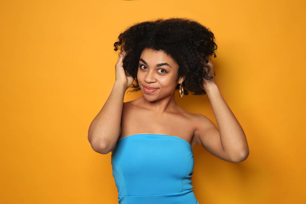 Portret van jonge Afro-Amerikaanse vrouw op kleur achtergrond - Foto, afbeelding