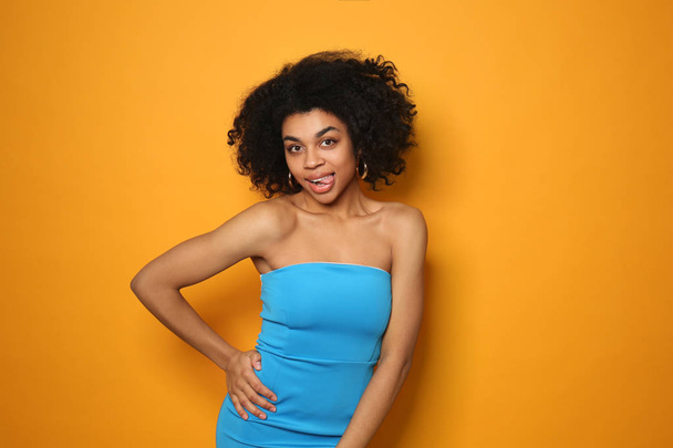 Portrait of young African-American woman on color background - Photo, Image