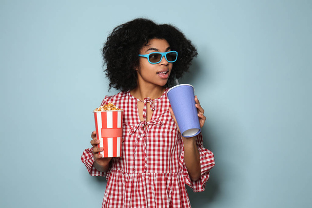 Nuoren afroamerikkalaisen naisen muotokuva juomalla ja popcornilla väritaustalla
 - Valokuva, kuva