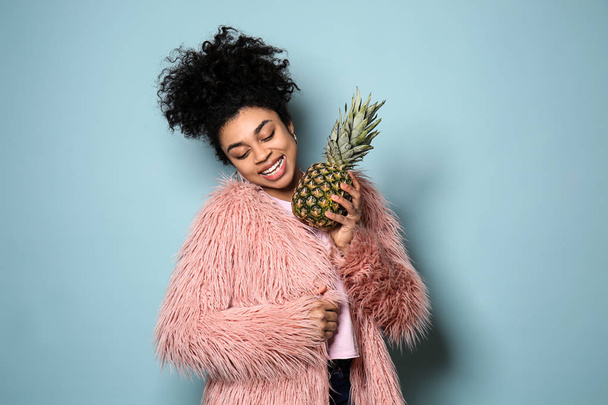 Portrait of young African-American woman with pineapple on color background - Fotografie, Obrázek