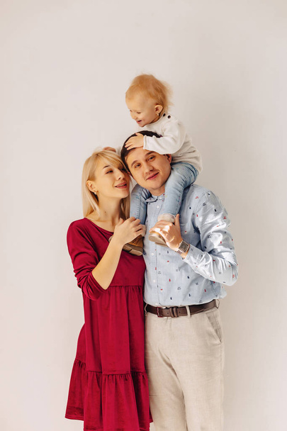 beautiful family with a small daughter, a simple background, happiness and joy in apartments - Valokuva, kuva