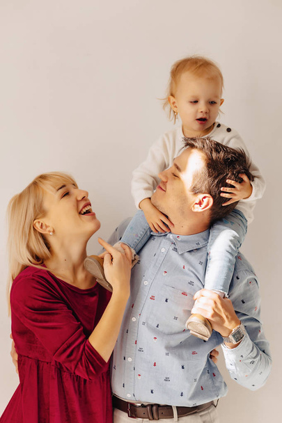 bella famiglia con una figlia piccola, uno sfondo semplice, felicità e gioia negli appartamenti
 - Foto, immagini