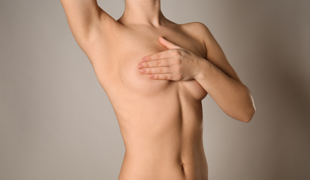Mujer desnuda sobre fondo gris. Concepto de aumento de senos
 - Foto, Imagen