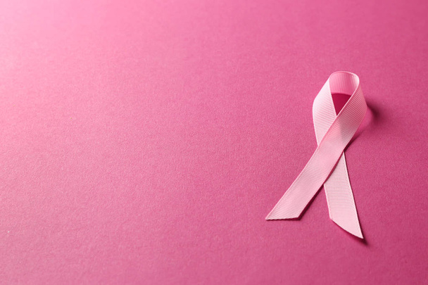 Pink ribbon on color background. Breast cancer awareness concept - Foto, Imagem