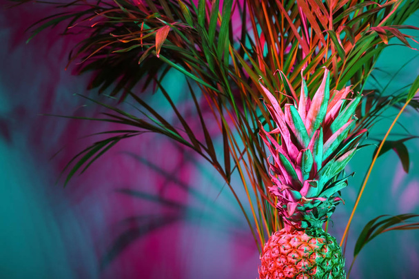 Fresh pineapple and tropical palm on color background - Photo, Image