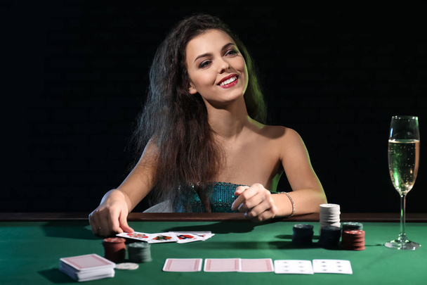 Kaunis naispuolinen pelaaja pöydässä kasino
 - Valokuva, kuva