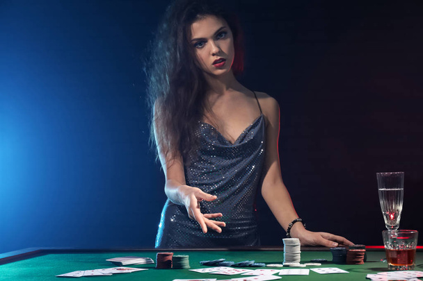 Beautiful female player at table in casino - Foto, afbeelding