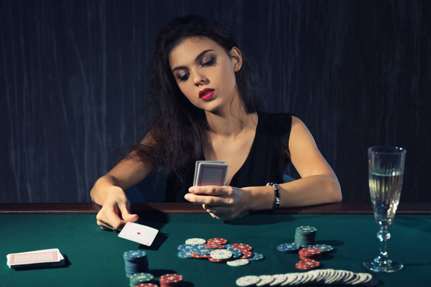 Beautiful female player at table in casino - Fotoğraf, Görsel