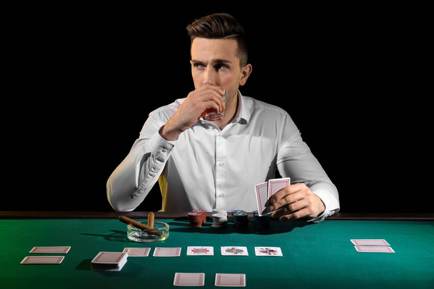 Красивий чоловічий гравець за столом в казино
 - Фото, зображення