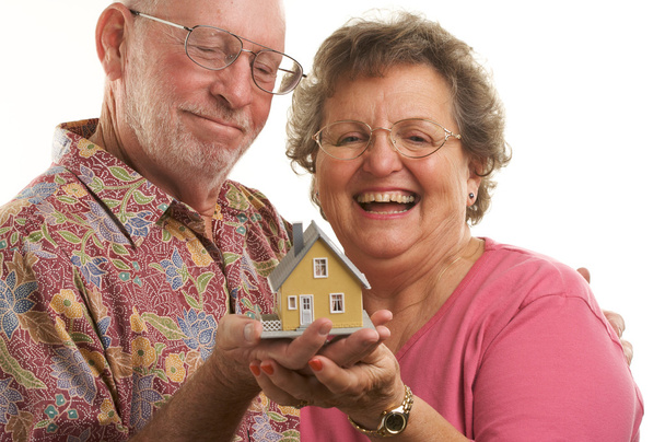 Heureux couple aîné tenant une maison modèle
 - Photo, image