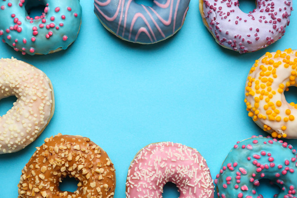 Quadro feito de doces donuts saborosos no fundo de cor
 - Foto, Imagem