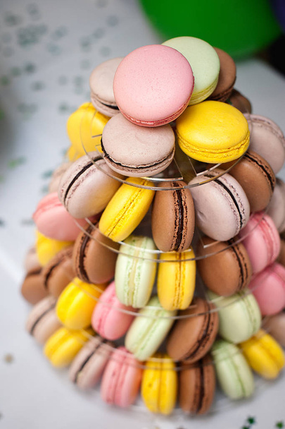 kleurrijke Franse macarons multilevel taart piramide op kunststof dessert stand. - Foto, afbeelding