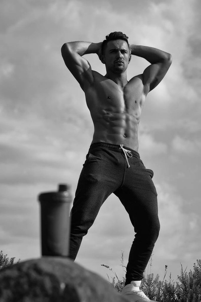 muscular man posing near water bottle - Φωτογραφία, εικόνα