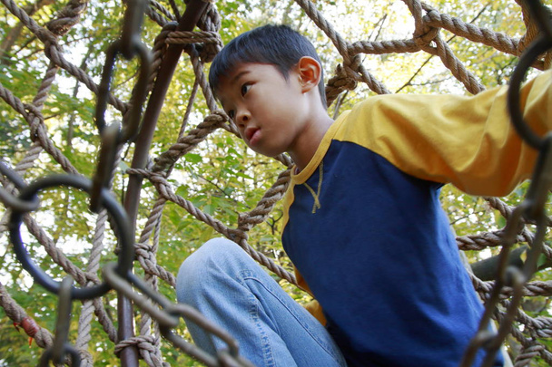 Japanischer Junge spielt im Outdoor-Hindernisparcour (3. Klasse Grundschule)) - Foto, Bild