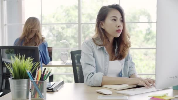 Ázsiai ügyfél szolgáltatás nők számítógép segítségével választ ügyfél e-mail asztalon, női íróasztal hivatalban ülve laptop dolgozik. Életmód nők munkában office koncepció. - Felvétel, videó