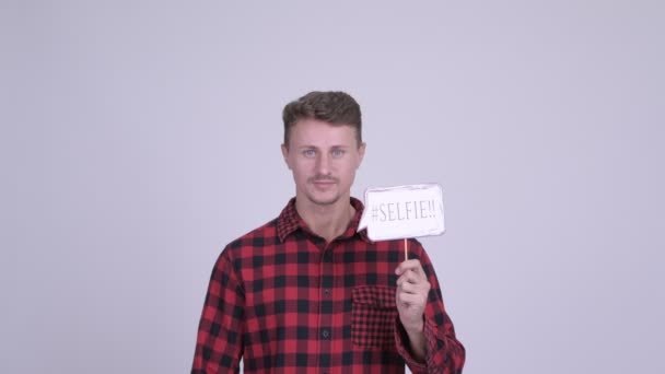 Happy bearded hipster man shouting while holding selfie paper sign - Video