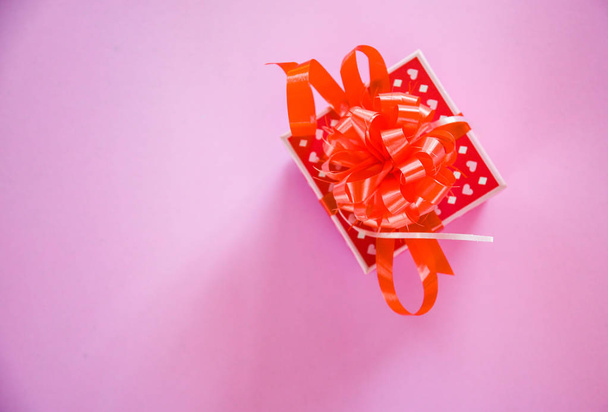 Caja de regalo concepto de San Valentín rojo / Caja de regalo roja con lazo de cinta sobre fondo rosa
  - Foto, imagen