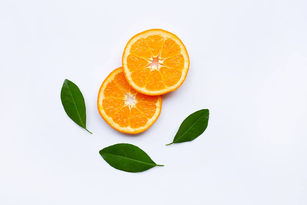 Fatias de laranja frescas, frutas cítricas com folhas no fundo branco. Vista superior
 - Foto, Imagem