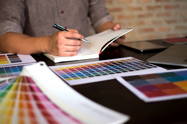 Графические дизайнеры выбирают цвета из образцов цветовых полос для дизайна.
 .  - Фото, изображение