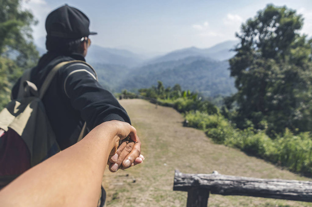 Couple summer vacation travel. Man walking on romantic holidays holding hand of wife following him at scenic summer mountains landscape.Tourism vacation and travel. - Fotoğraf, Görsel