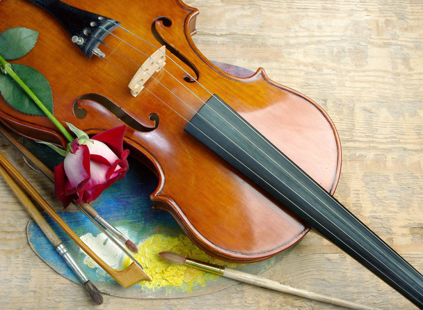 ヴァイオリン、ブラシ、木製の背景のパレット. - 写真・画像
