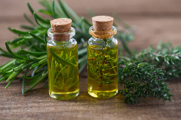 olive oil with herbs on wooden surface - 写真・画像