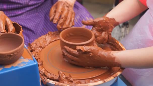 Hands of potter teaches the child how to make pots. Concept - transfer of experience, training - Footage, Video