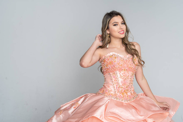 Hispanic teen girl wearing a quinceanera dress for her party - Foto, afbeelding