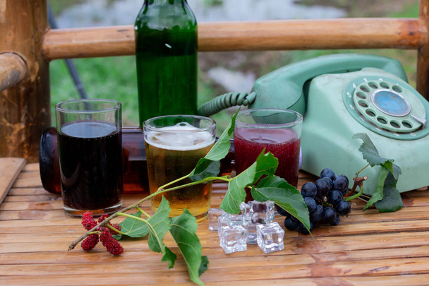 σταφύλι, κρασί και βαρελίσια μπύρα σε ποτήρι στην καρέκλα από μπαμπού - Φωτογραφία, εικόνα