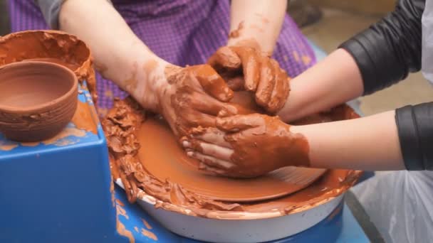 A fazekas kezek megtanítják a gyereket edényeket készíteni. Koncepció - tapasztalatátadás, képzés - Felvétel, videó
