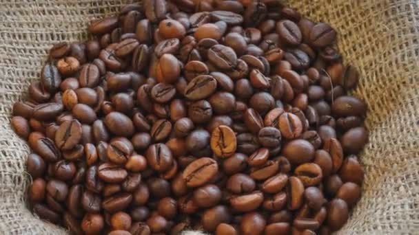 Natural brown roasted coffee beans on burlap texture. Seamless rotating background. - Video, Çekim