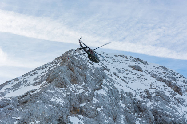 Rettungshubschrauber fliegt nahe Bergkette, um Verletzte zu bergen. - Foto, Bild