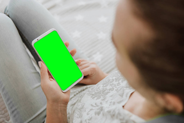 holding mobile phone. close up. Mockup chroma Green screen smartphone. key image of woman's hands - Photo, image