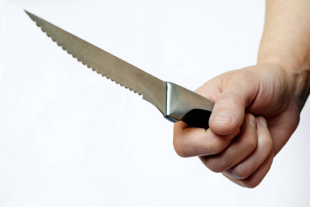 Стальной нож в женской руке на белом фоне. Проблема домашнего насилия. Защита и атака
.                                - Фото, изображение