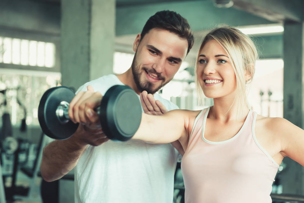 Beautiful sexy woman in fitness gym training with fitness equipment in sport gym and many bodybuilding, Lifting weight loss ,Portrait couple people exercise body gym Sporty and healthcare concept. - Zdjęcie, obraz