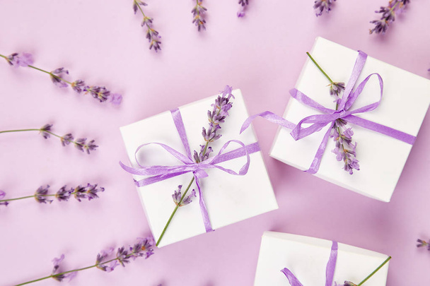 White Gift box with violet ribbon and bouquet of flower lavender on pink background. Celebration, birthday. Decoration present. Flat lay. Copy space. - Photo, Image